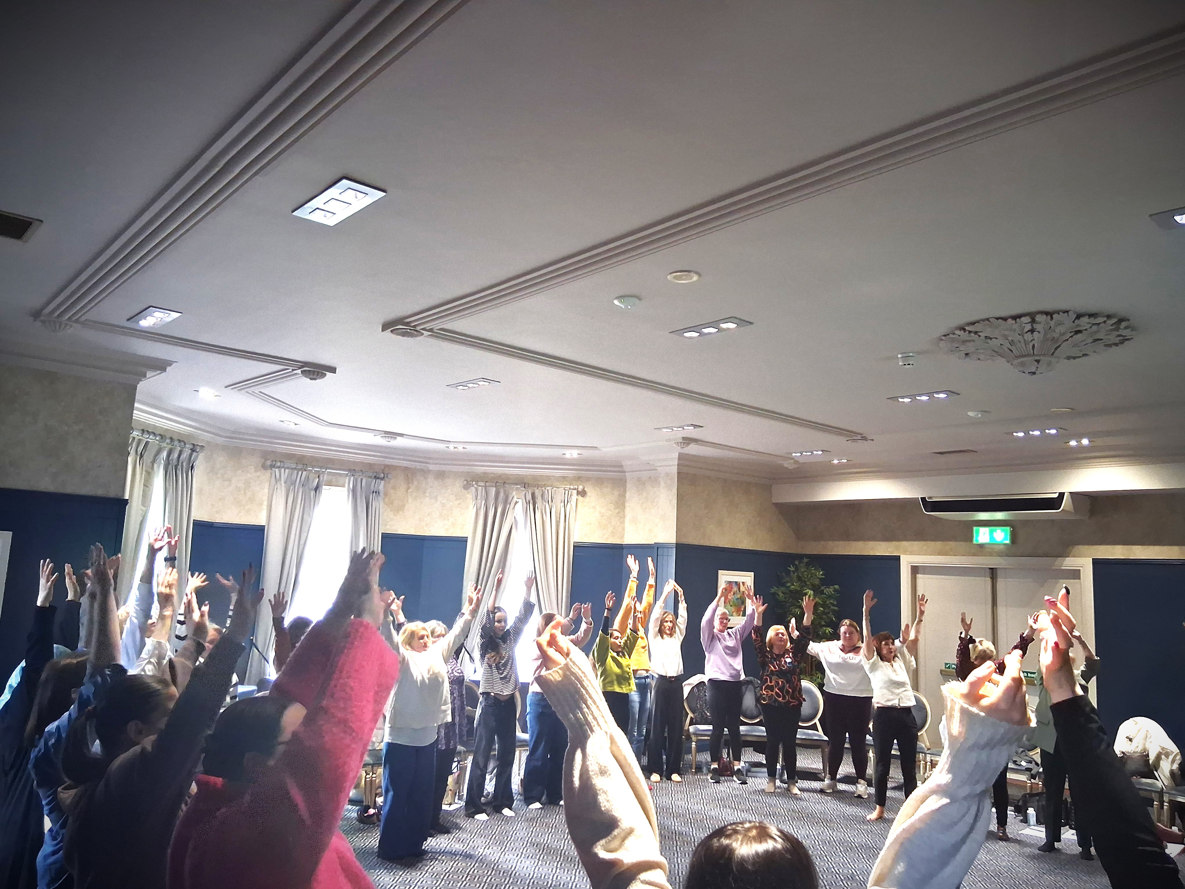Educators with arms raised during a music and movement activity